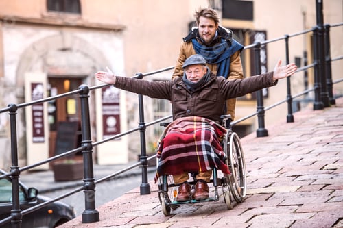 Preview: Senior father in wheelchair and young son on a walk.