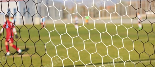 Preview: Soccer nets and football game in arena. Blurred players background.