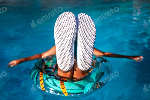Preview: Teen in pool with upturned soles, perfect for text placement.