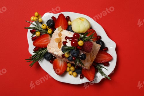 Preview: Delicious Pavlova Dessert Garnished With Berries on Red