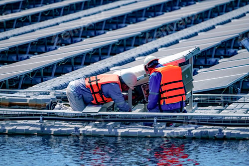 Preview: Local worker working at floating solar panels platform on the water of solar cell power plant.