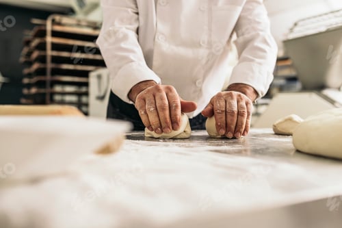 Preview: Baker kneading dough in a bakery.