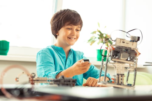 Preview: Cheerful boy being happy trying his robot model