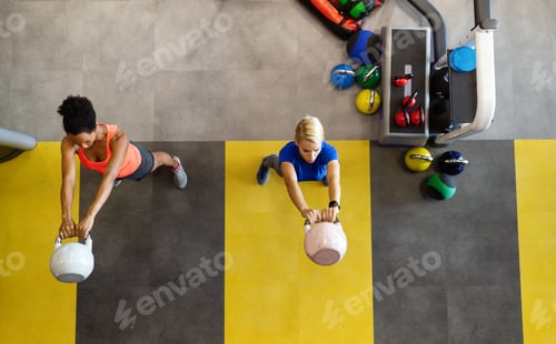 Preview: Group of young happy fit people doing exercises in gym