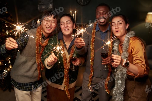 Preview: Portrait of Smiling People Holding Bengal Lights while Celebrating Christmas at Home