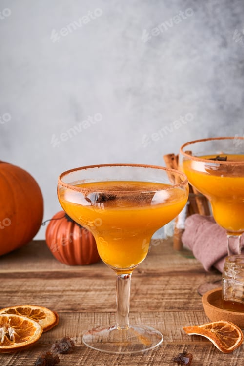 Preview: Pumpkin cocktail with cinnamon, orange juice and cocoa in glass mugs. Festive cocktail Halloween mar