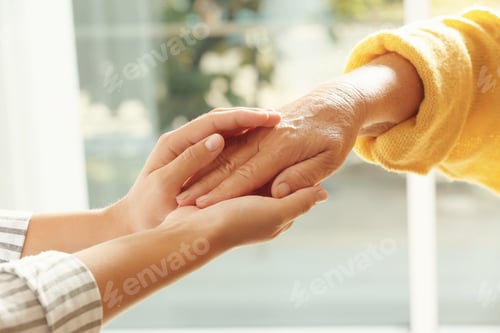 Preview: Helping hands on blurred background, closeup. Elderly care concept
