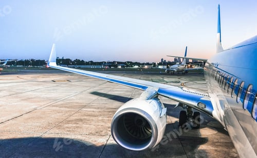 Preview: Airplane at terminal gate ready for takeoff at blue hour