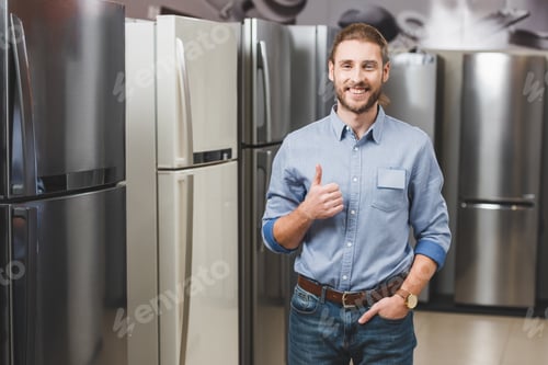 Preview: smiling consultant showing like near fridges in home appliance store