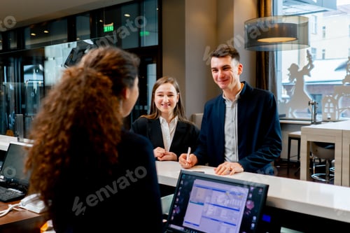 Preview: The receptionist at the counter meets guests with luggage in the hotel business travel hospitality