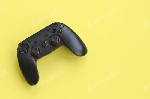 Preview: Modern black gamepad on yellow background close up. Esports and cyber sport tournament concept
