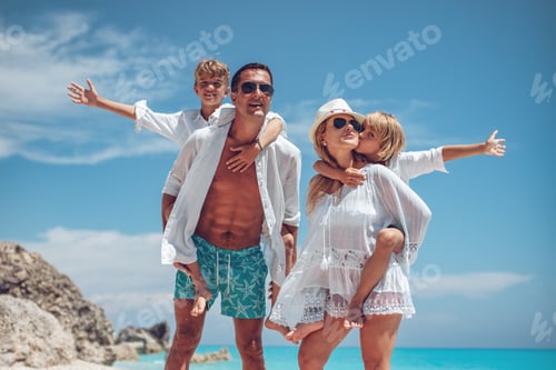 Preview: Happy Family Enjoying Piggyback Rides on Tropical Beach