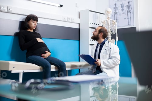Preview: Doctor consulting with pregnant patient