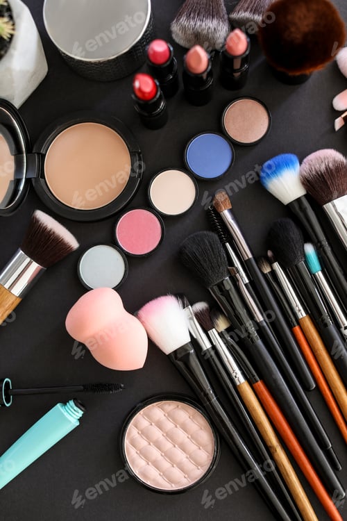 Preview: Flat lay composition with makeup brushes and cosmetic products on black background