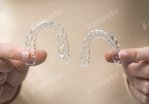Preview: hands holding transparent retainer