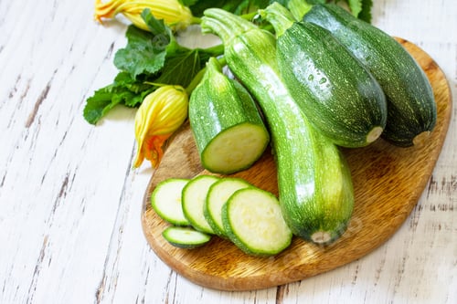 Preview: Fresh healthy green zucchini on a wooden kitchen table.