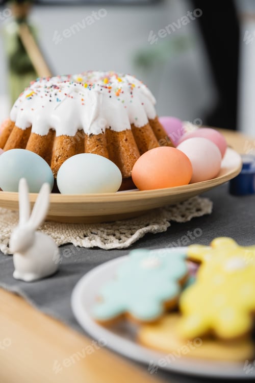 Preview: Easter cake and colorful eggs near rabbit on table