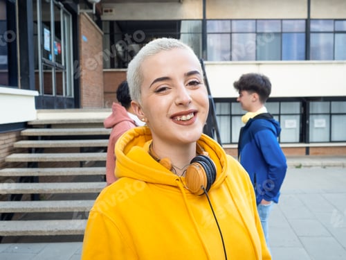 Preview: Portrait of a smiling alternative young woman with short hair looking at camera