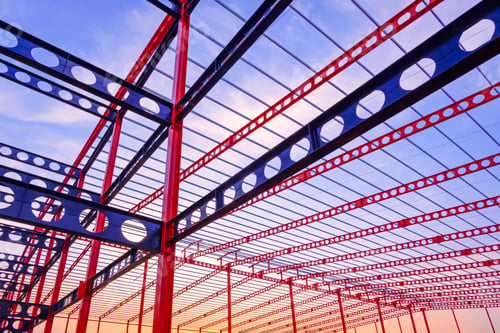 Preview: Metal castellated beam structure of large industrial building in construction site at sunset time