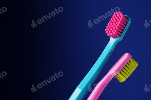 Preview: Two bright plastic toothbrushes on a dark blue background. There is a place for text.