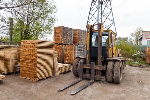 Preview: Large lift truck and stacks of new wooden boards and studs at the lumber yard.