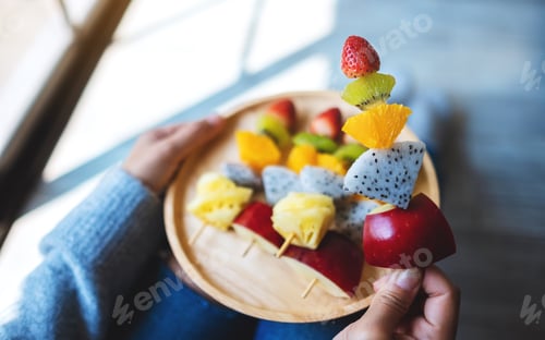 Preview: Person Holding a Delicious Plate of Fruit Skewers