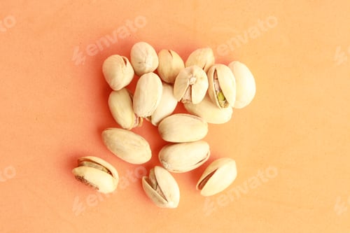 Preview: Top view of roasted pistachios in shell on orange background