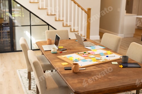 Preview: Brainstorming ideas, laptops and sticky notes on table in modern home office