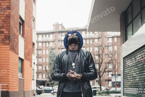 Aperçu: portrait of young african man standing in the street and looking up
