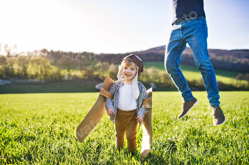 Preview: Happy toddler boy playing outside with father in spring nature.