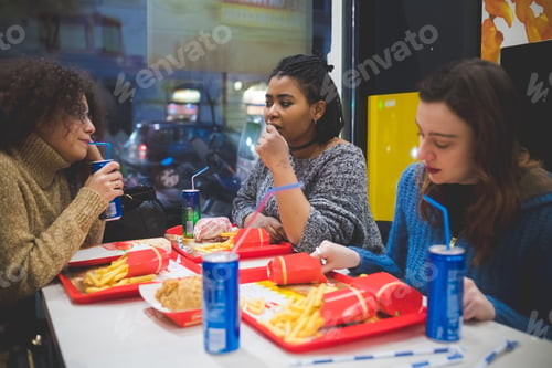 Preview: three multiracial girlfriends eating and drinking together