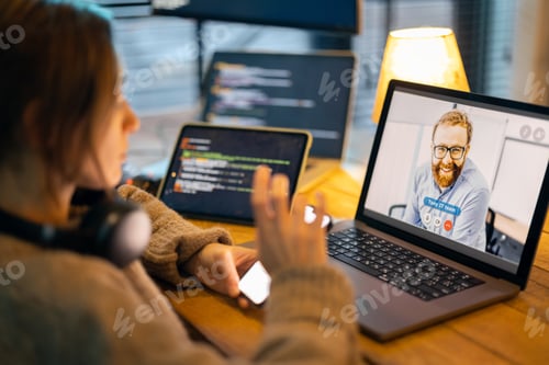Preview: Woman talking online with a male colleague at home office