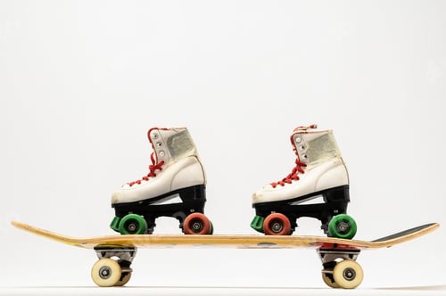 Preview: White rollerskates with colorful wheels on a skateboard on white background