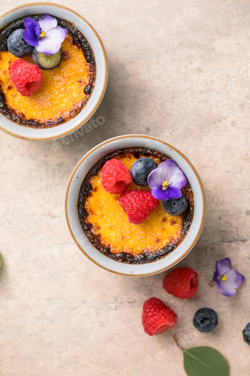 Preview: Creme brulee. French vanilla cream dessert with caramelised sugar and berries, selective focus.