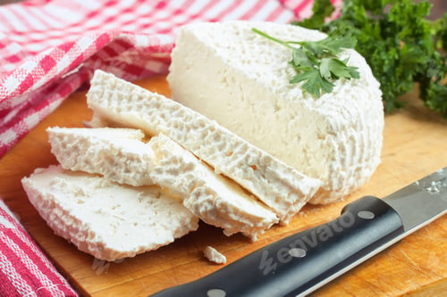 Preview: Slices of fresh cottage cheese on wooden cutting board