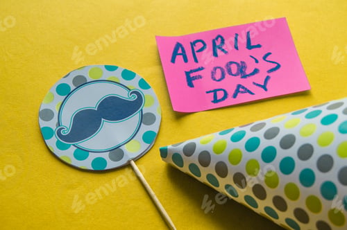 Preview: Cap, topper with a mustache and notes with the phrase April fool's day on a yellow background