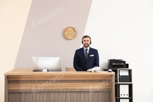 Preview: Portrait of receptionist working at desk in modern hotel