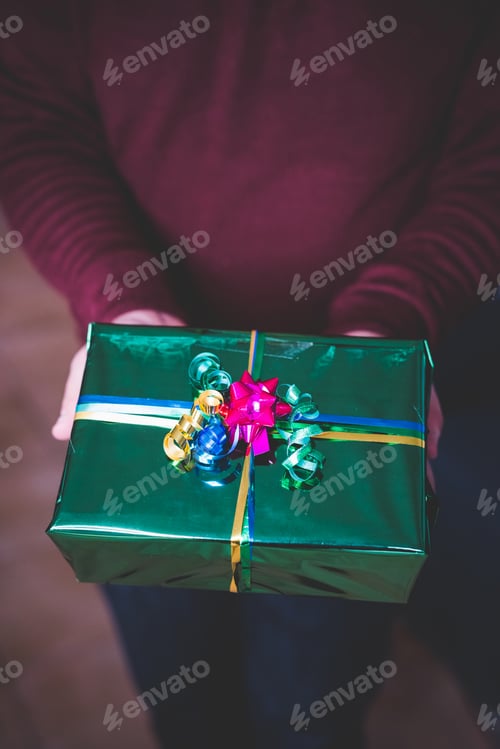 Preview: Young man at home wrapping xmas present