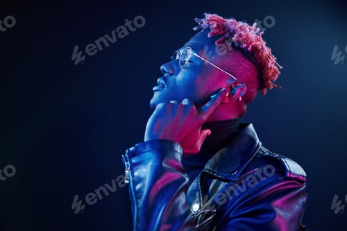 Preview: Listening to the music. Futuristic neon lighting. Young african american man in the studio