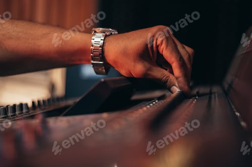 Preview: Music producer hands while working on a mixing soundboard while in his studio