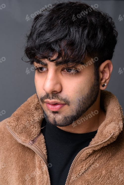 Preview: Young handsome Indian man against gray background