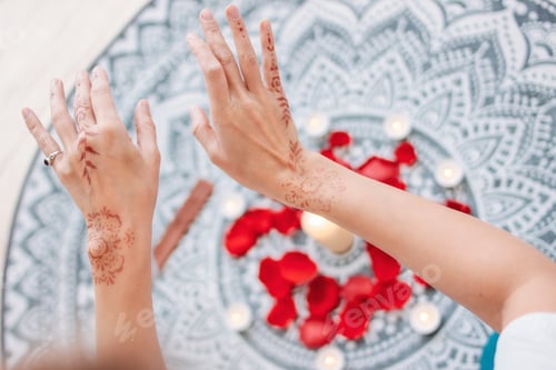 Preview: Dance of female hands with mehendi over the altar of candles and rose petals, women practices