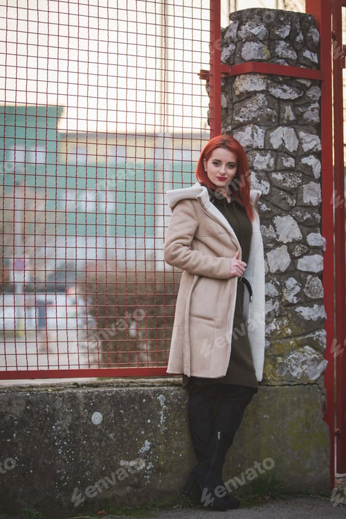 Preview: Young Caucasian female wearing a green dress and a jacket posing outdoors