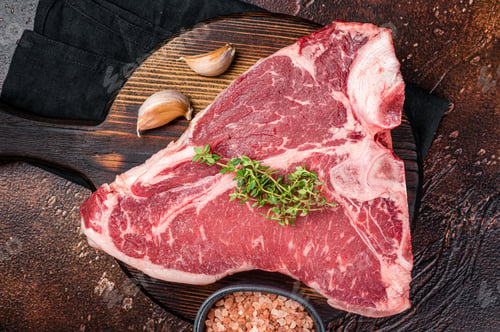 Preview: Raw Porterhouse steak, marbled beef meat on a wooden board. Dark background. Top view