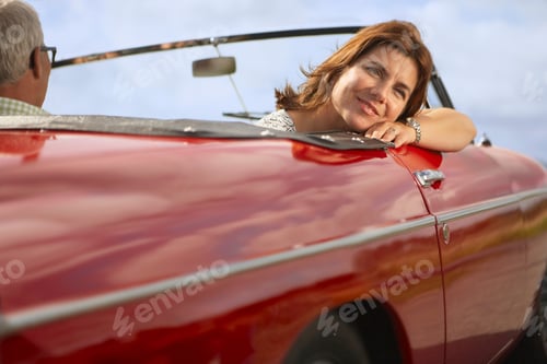 Preview: Mid aged couple in sports car