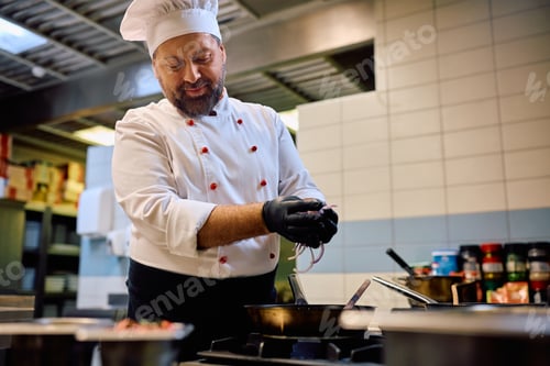 Preview: Professional cook preparing food in a restaurant kitchen.