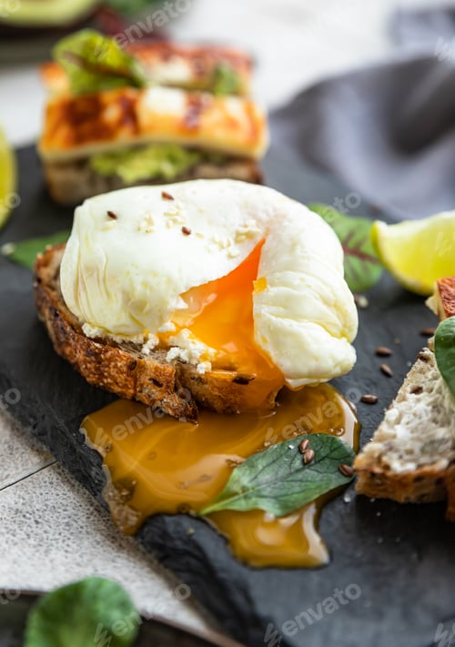Preview: Sandwiches with poached egg, avocado and grilled cheese with salad leaves