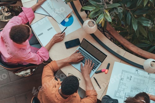 Preview: Top view of coworkers working together at modern office. Workplace and cooperation concept