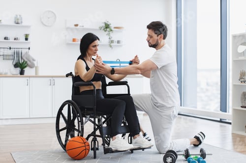 Preview: Woman in Wheelchair Doing Exercise With Trainer