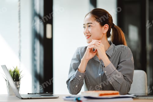 Preview: Asian businesswoman working at office using laptop and documents on table Plan to analyze financial